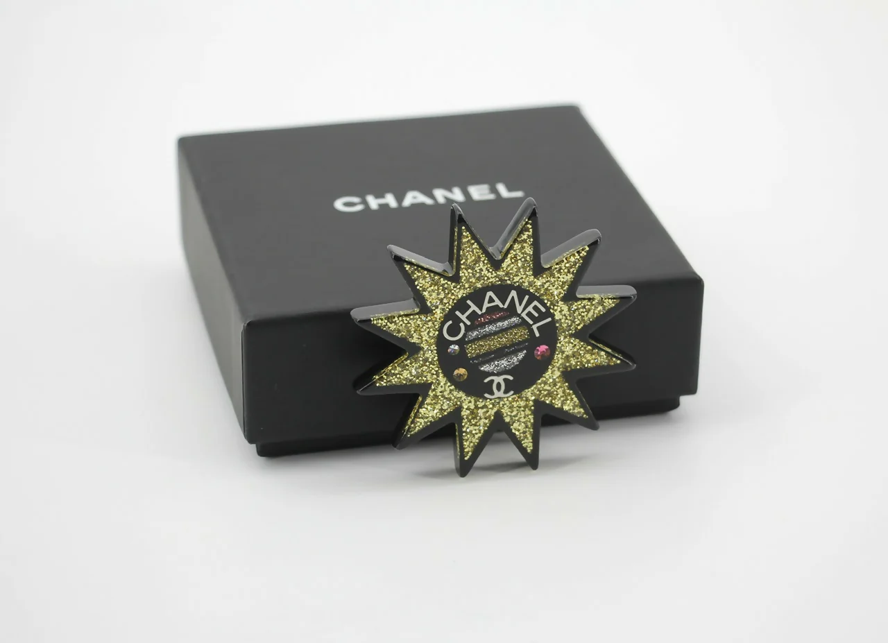 Chanel 17K Acrylic Black & Gold Micro-Sparkle Sun Motif Brooch