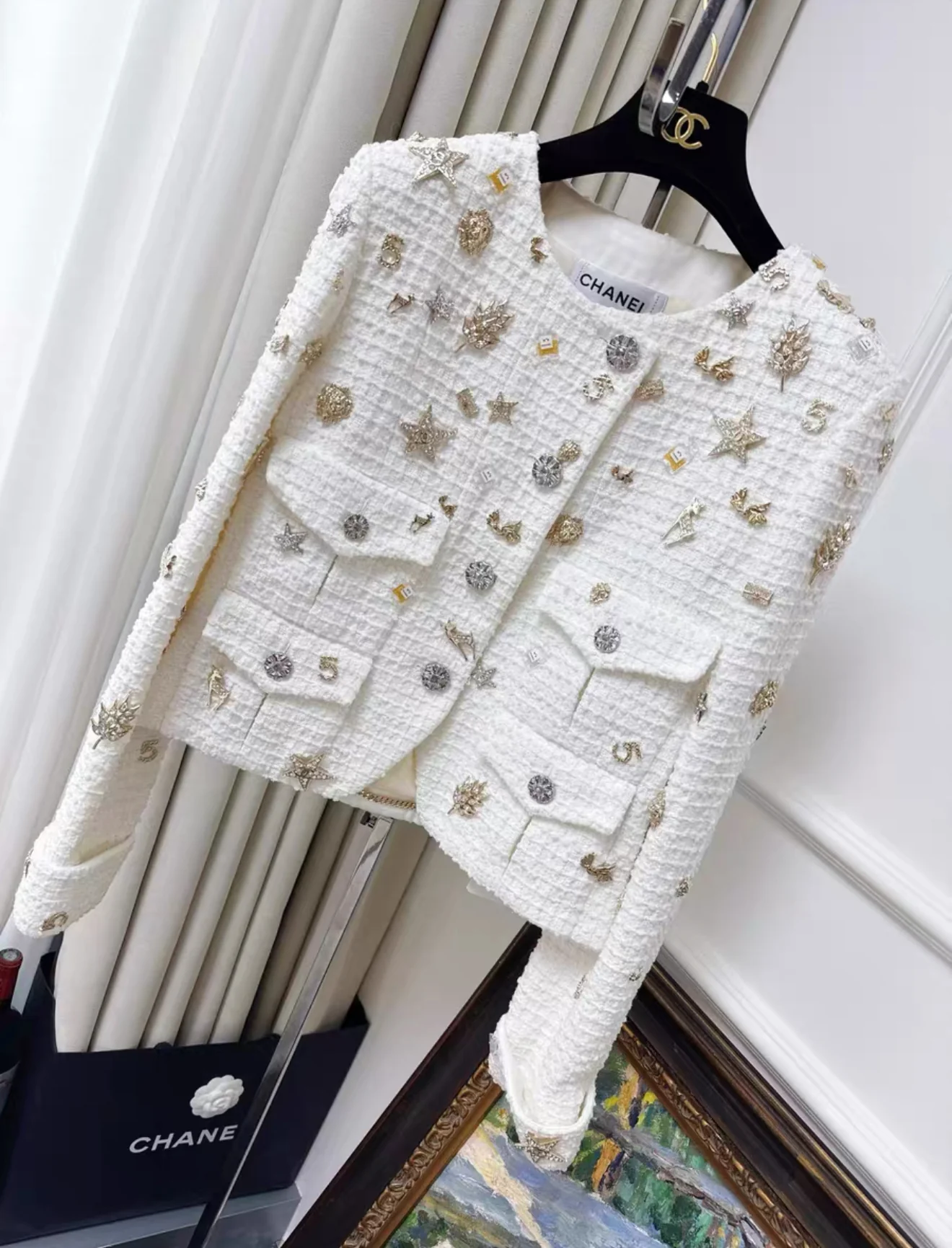 Chanel 22C White tweed jacket decorated with charms